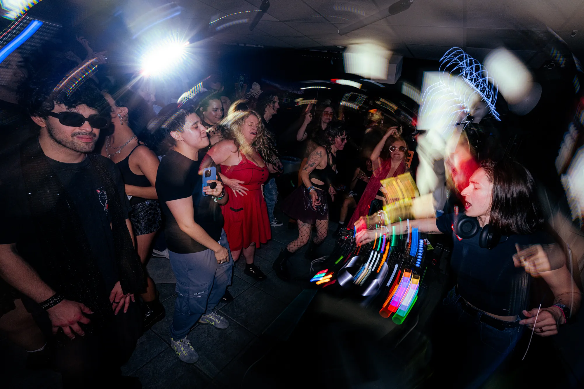 Dancers circle up mid-set as beams of light sweep across the floor