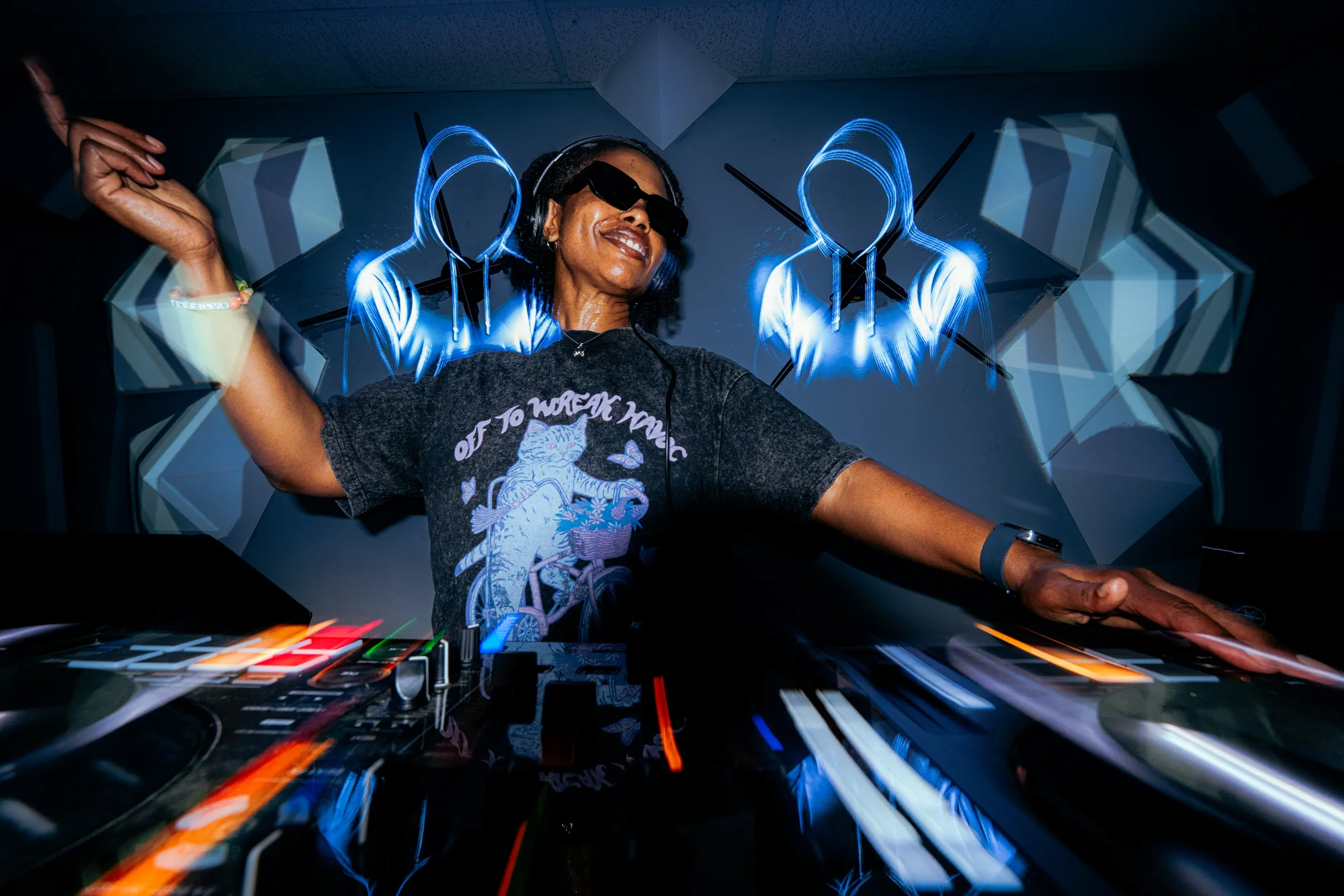 The DJ throws both arms up and calls the whole room to its feet